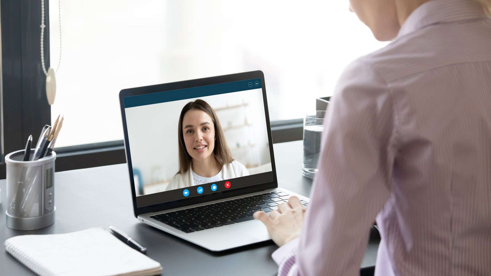 A Vitality clinician in a telehealth video session with a client on a laptop